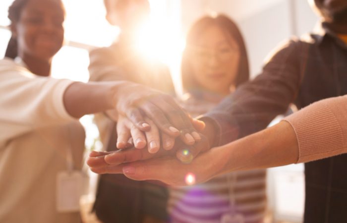 Pessoas diversas de uma empresa dando as mãos